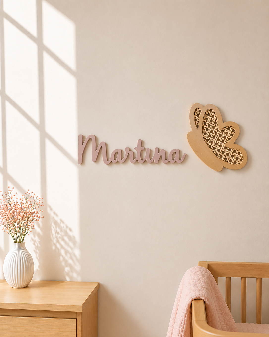 Mariposa de madera y ratán en la pared junto al nombre Martina en habitación infantil