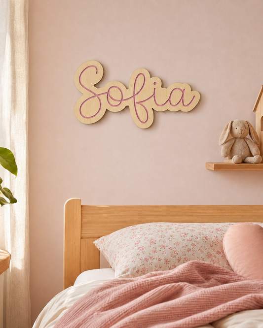 Nombre de madera Sofía en letra cursiva colgado en la pared sobre cama infantil rosa