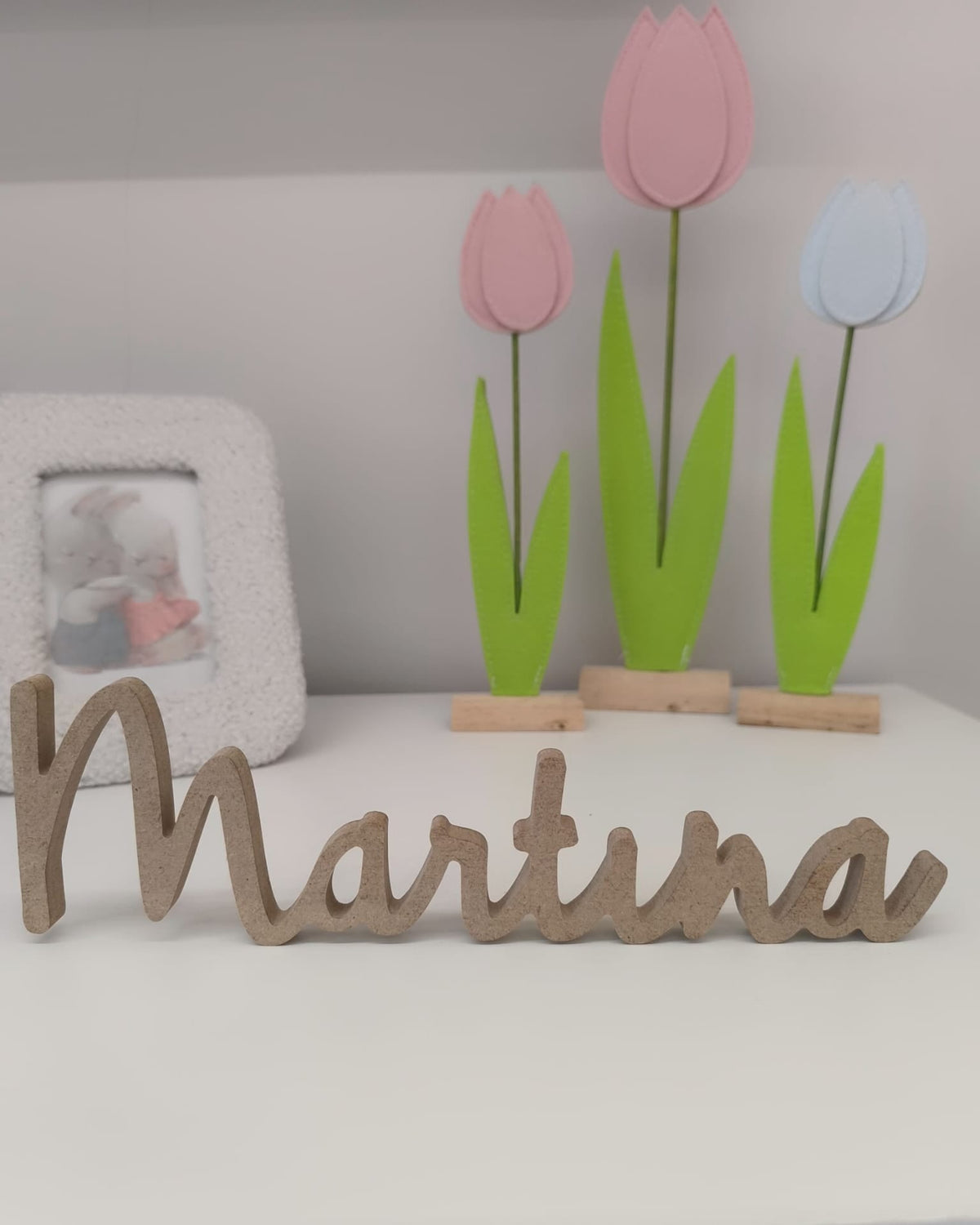 Nombre de madera ligado Martina en letra cursiva sobre estantería infantil